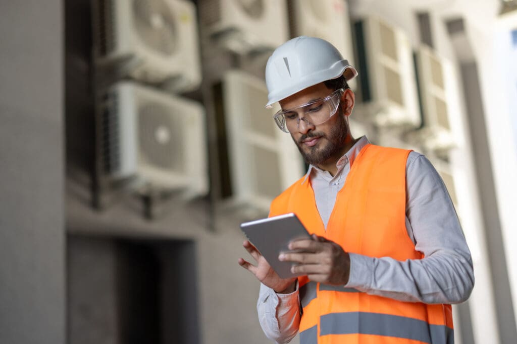 Building engineer reviewing fault detection and data driven maintenance dashboard, illustrating fdd vs ddm